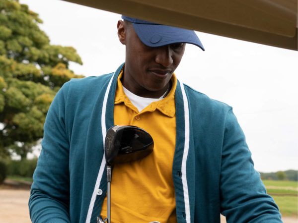 A golfer taking clubs out of a buggy at Woolfox members club in Stamford, Rutland